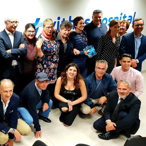 Unas veinte personas de la asociación, familias y especialistas posan juntas sonriendo en el Hospital Vithas Las Palmas